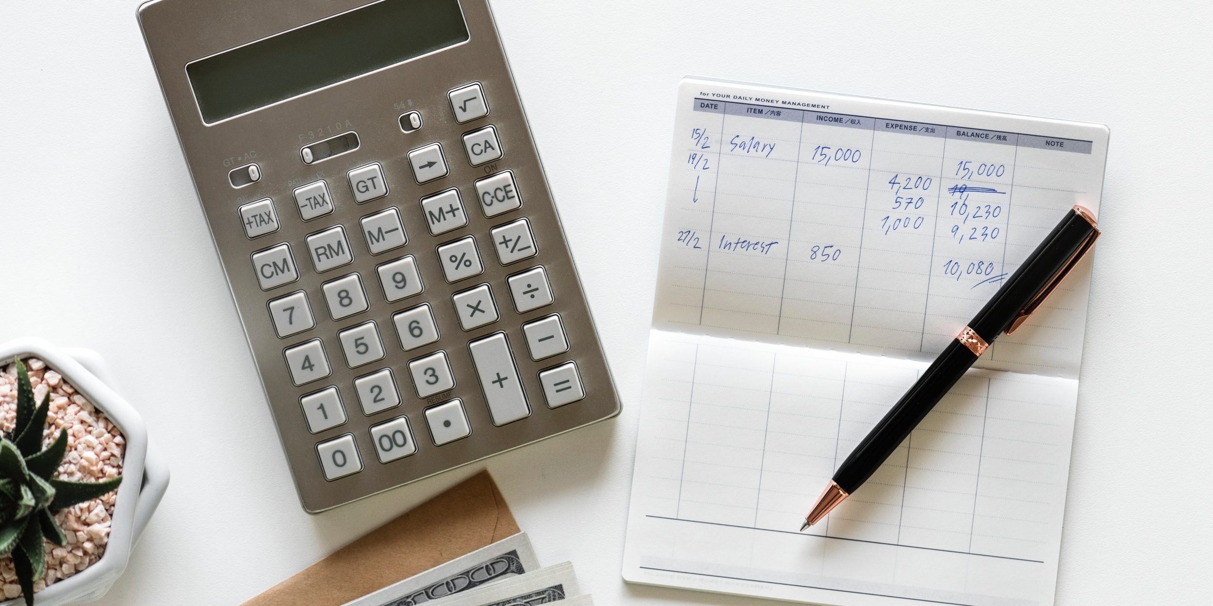 Calculadora e caderno mostrando cálculos matemáticos